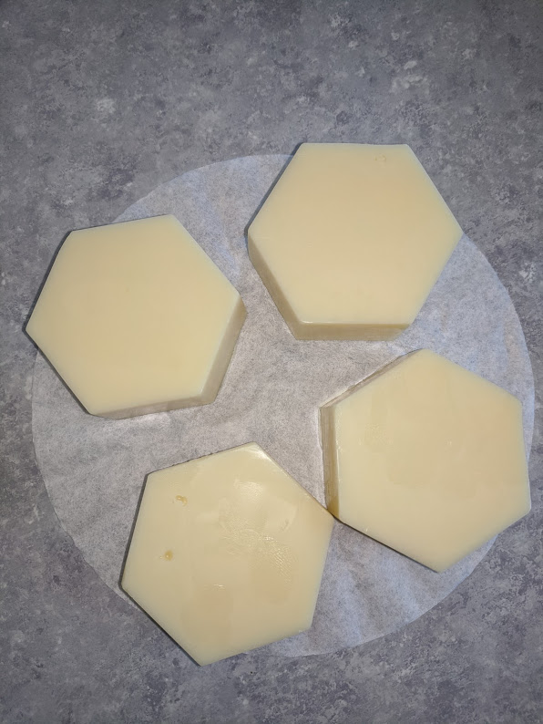 4 hexagonal lotion bars sitting on a counter.