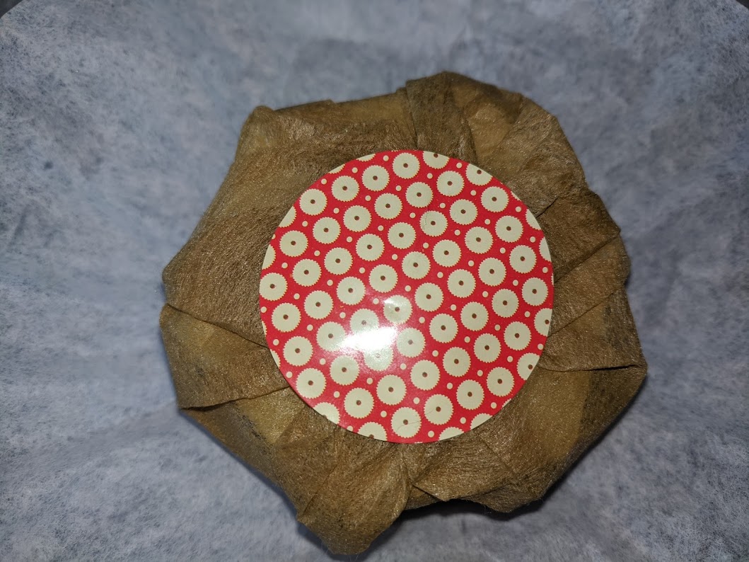 A single lotion bar wrapped in gold paper with a sticker.